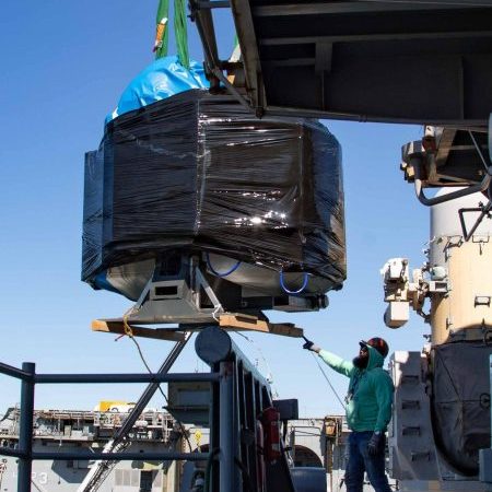 Kenya Latham, assigned to East Coast Repair, coordinates the on-load of a three-dimensional printer aboard the Wasp-class amphibious assault ship USS Bataan. This is the first Naval Sea Systems Command sponsored hybrid system permanently installed on a US Navy ship and will permit the capability to additive manufacture stainless steel components locally. (Photo by Mass Communication Specialist 2nd Class Darren Newell/Released).