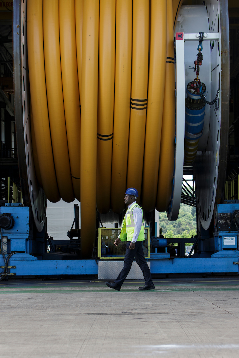 BHGE Flexible Pipe Solutions Man walking in front of gigantic spool with flexible pipe