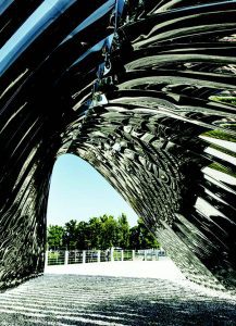The mirror-polished stainless steel arches form a gate-like passageway with fascinating reflections. Photo © Zieta Studio