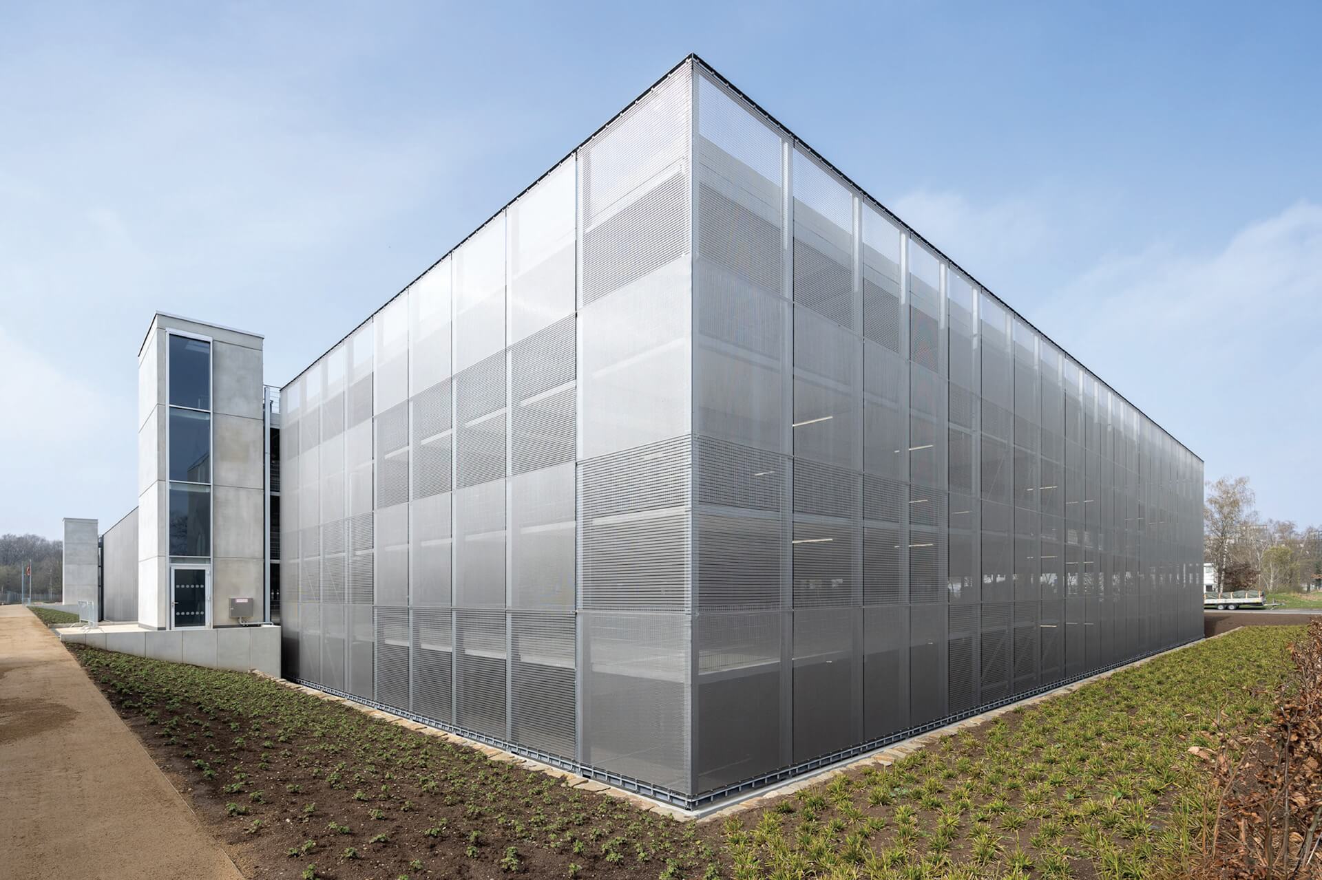 Innovative façade architecture: The architectural mesh façade of the Bonn Hardthöhe parking structure captivates with its textile character and dynamic transparency, creating a striking visual identity while subtly integrating into the urban context. Photo © N. Kazakov Innovative façade architecture: The architectural mesh façade of the Bonn Hardthöhe parking structure captivates with its textile character and dynamic transparency, creating a striking visual identity while subtly integrating into the urban context. Photo © N. Kazakov